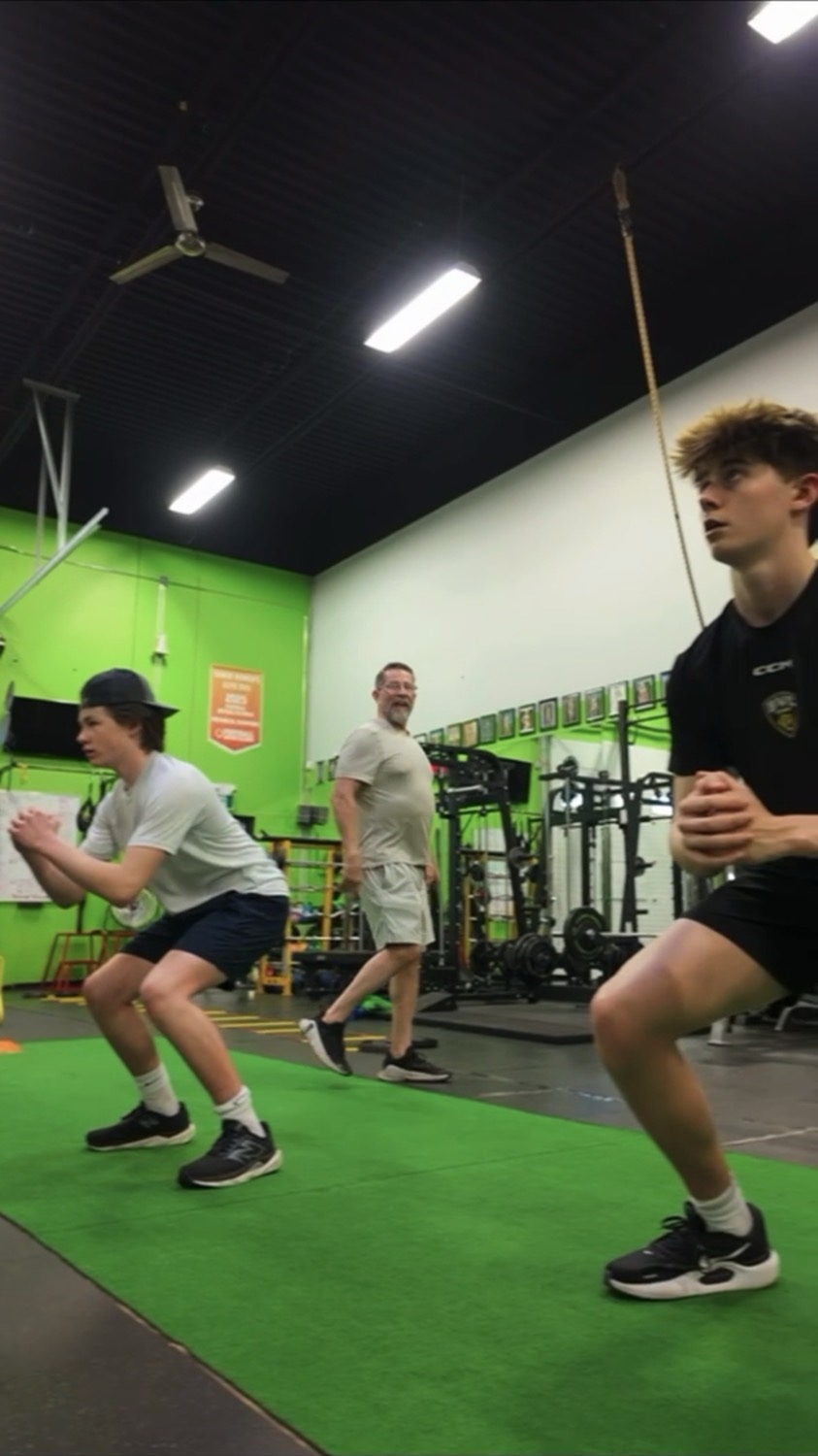 Hockey athletes training off-ice under coach supervision